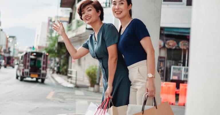 Places & Attractions Blogs | Articles | News | Tips & Tricks | Video | FAQ | Information | Infograph. 3 Low angle of smiling female friends with paper bags catching cab after shopping in mall