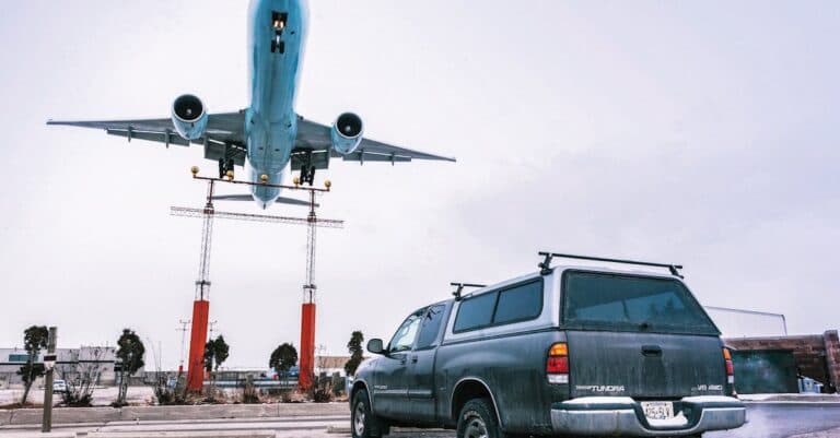 Airport Transfer Blogs | Articles | News | Tips & Tricks | Video | FAQ | Information | Infograph. 21 A striking image capturing an airplane landing closely over a parked truck on a tarmac.