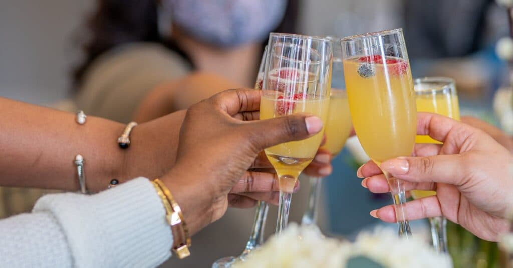 How to Travel from Brooklyn to Washington D.C. A Guide by JetBlack! 7 A diverse group toasting with mimosas in Washington, DC indoors.