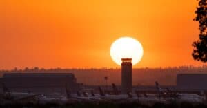 Airplanes at San Bernardino Airport silhouetted against a vibrant sunset.