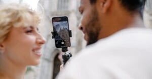 A happy couple taking a photo with a mobile phone in front of a landmark.
