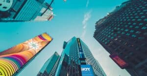 A low angle view of colorful skyscrapers in New York City with vivid signage.