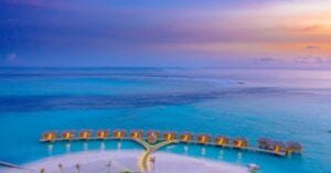 A breathtaking aerial shot of overwater bungalows in the Maldives during sunset.