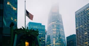 A misty view of New York's skyline featuring the American flag and modern skyscrapers.