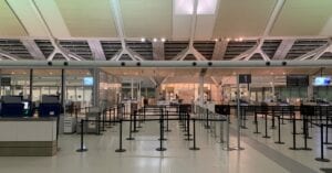Empty check-in area of a modern airport with sleek design and organized layout.