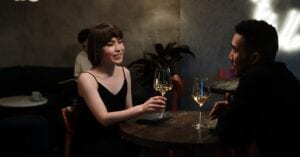 Couple enjoying a date night with white wine in a modern restaurant.
