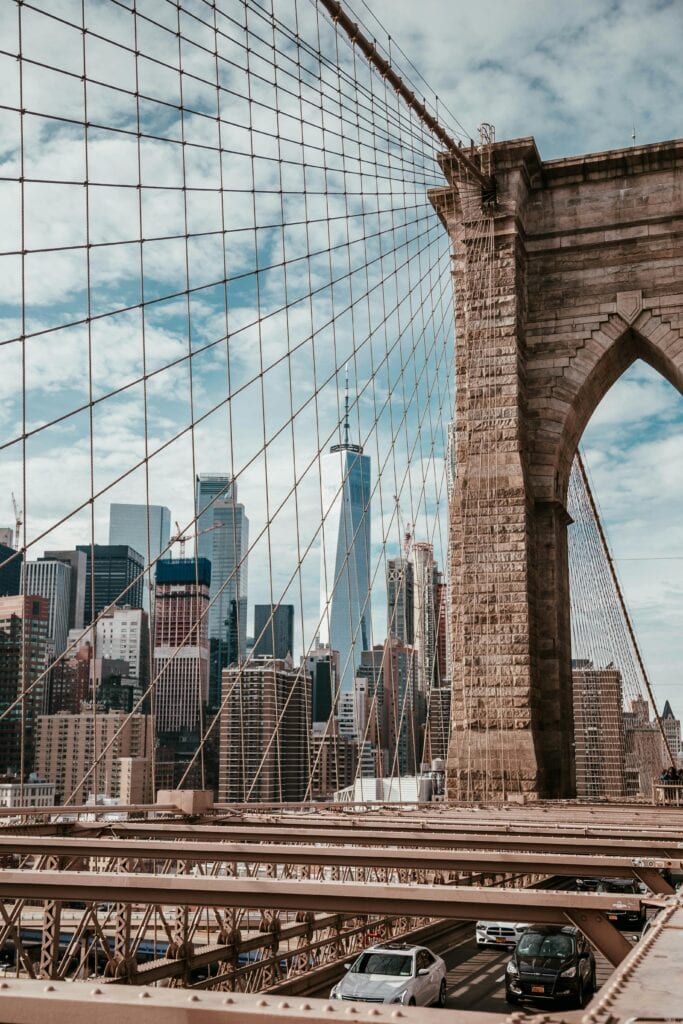 Iconic view of Brooklyn Bridge with Manhattan skyline and One World Trade Center in New York City.
