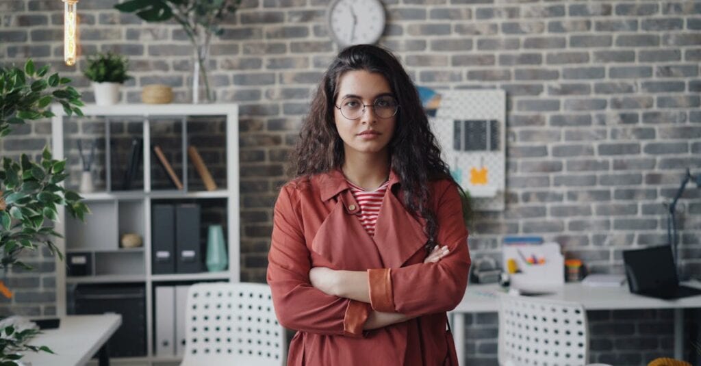 Young businesswoman with eyeglasses in stylish office with industrial decor.