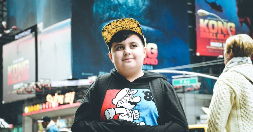 Young boy in a cartoon hoodie standing in Times Square, New York City.