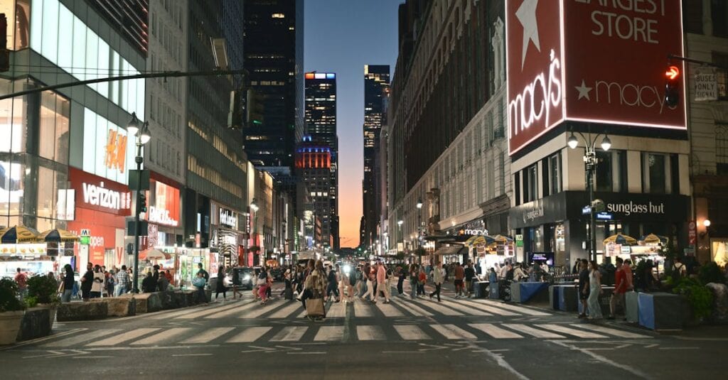 Evening scene at a busy New York intersection with pedestrians and neon lights.