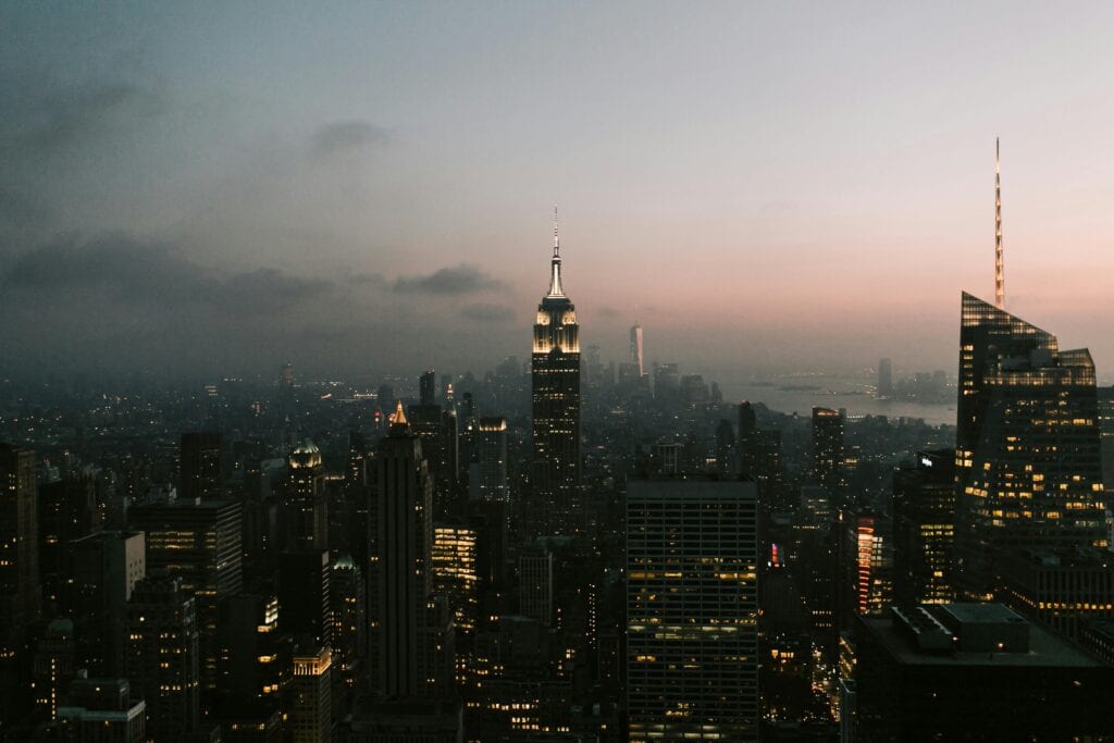 Twilight view of New York City skyline featuring the iconic Empire State Building.