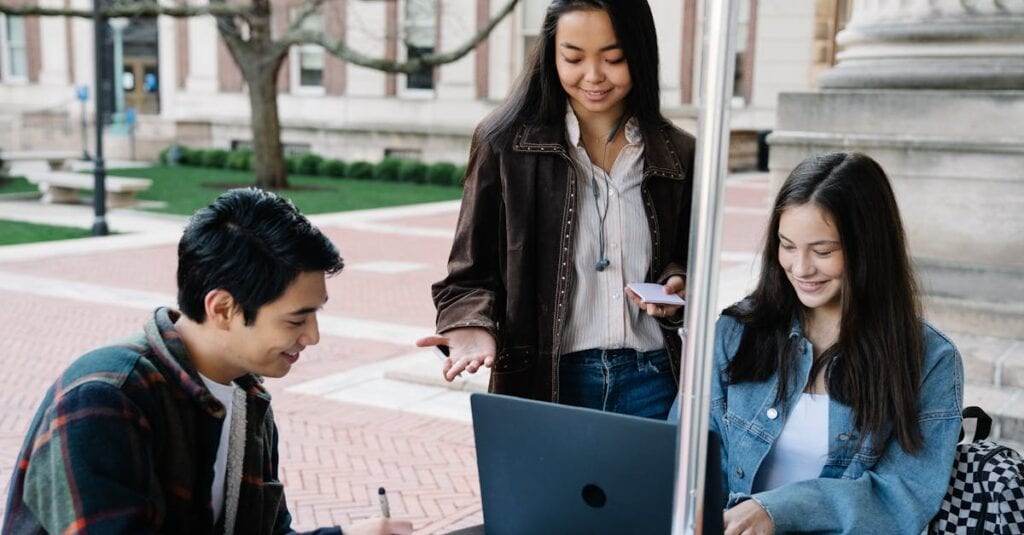 Group of university students collaborating and studying together in an outdoor setting.