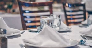 Sophisticated restaurant table setting with crystal glassware and white napkins, perfect for fine dining experiences.
