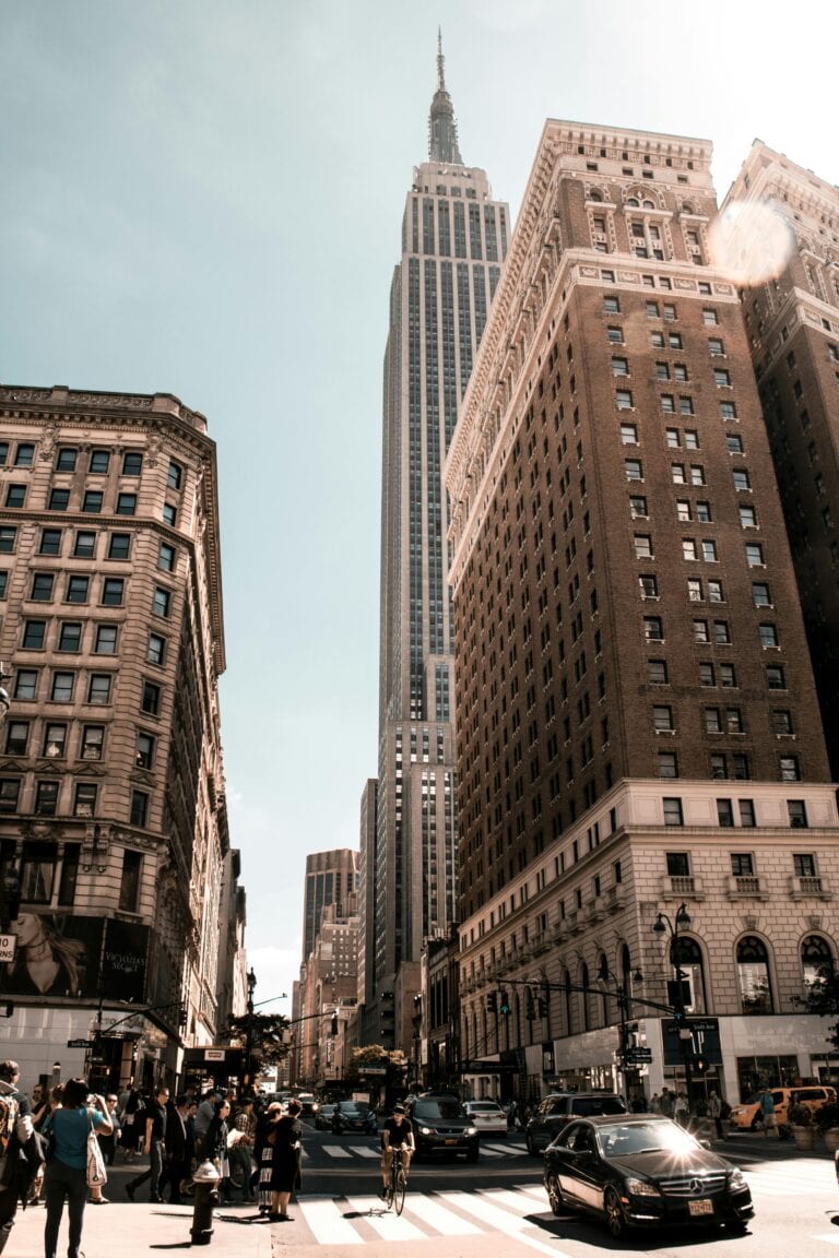 Bustling city life with iconic skyscraper under clear sky.