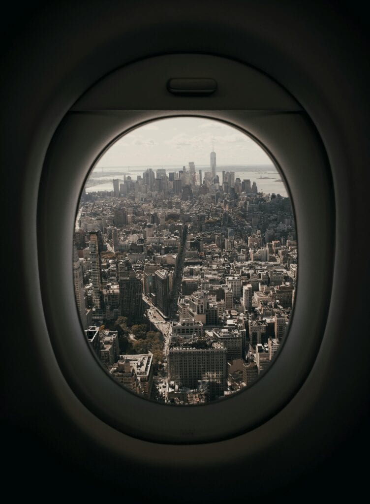 View of Manhattan skyline from an airplane window, showcasing urban architecture and iconic skyscrapers.