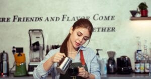 A barista prepares coffee in a trendy cafe with a welcoming ambiance.