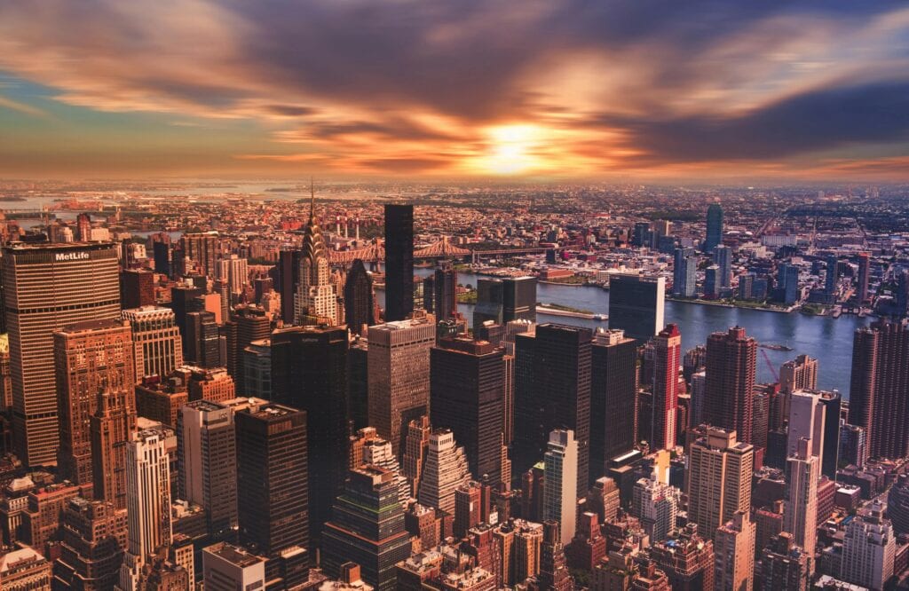 Stunning aerial view of New York City's skyline at sunset, showcasing iconic skyscrapers and vibrant colors.
