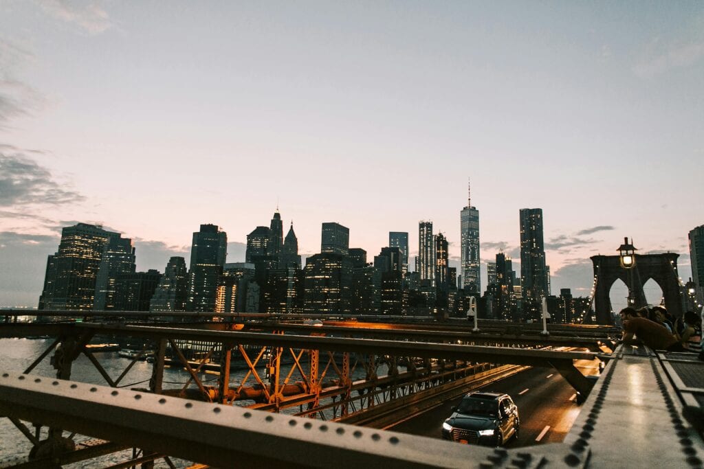 Breathtaking view of New York City's illuminated skyline from the Brooklyn Bridge at dusk.