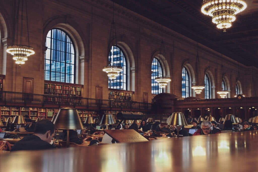 Group Van Rental Events NYC: Stress-Free Rides for Weddings, Corporate Parties & Big Nights Out in 2025 13 Interior view of a bustling reading room with chandeliers at the New York Public Library.