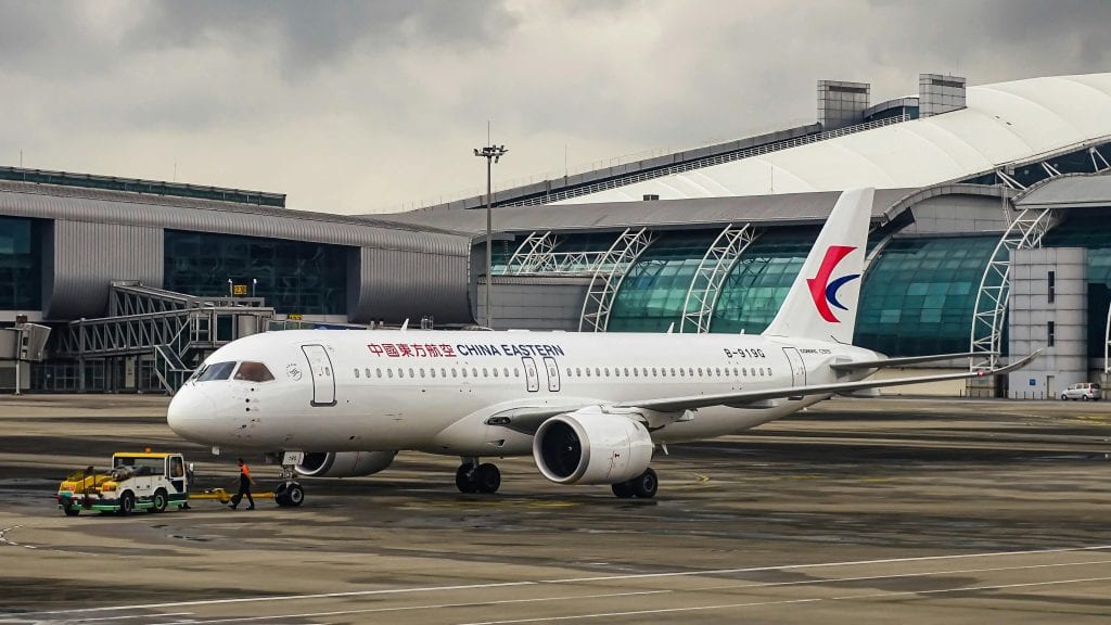 China Eastern Airlines Airbus A320 on the runway at a modern international airport terminal.