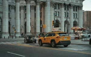 taxi laguardia to manhattan A typical New York City street with yellow taxi and historic architecture.