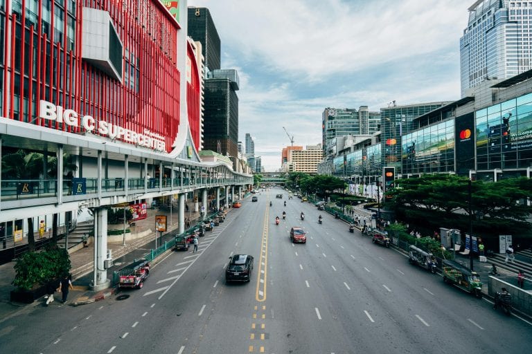 Dynamic view of Bangkok's Big C Supercenter, showcasing urban life, traffic, and architecture.