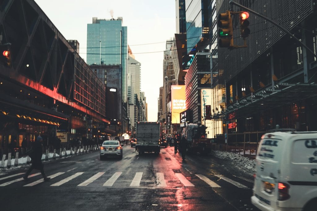 Iconic New York City street scene at twilight with traffic and skyscrapers.