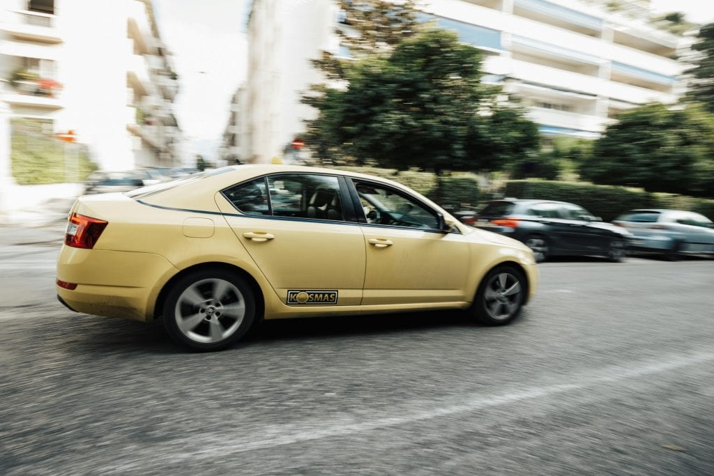 A yellow taxi speeds down a city street, capturing the essence of urban life and transportation.