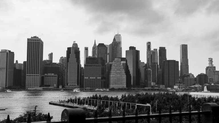 Black and white panorama of New York City skyline from waterfront.