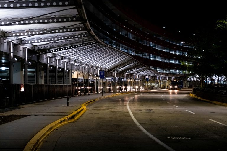 Modern architecture and empty roads at Chicago's O'Hare Airport captured at night.