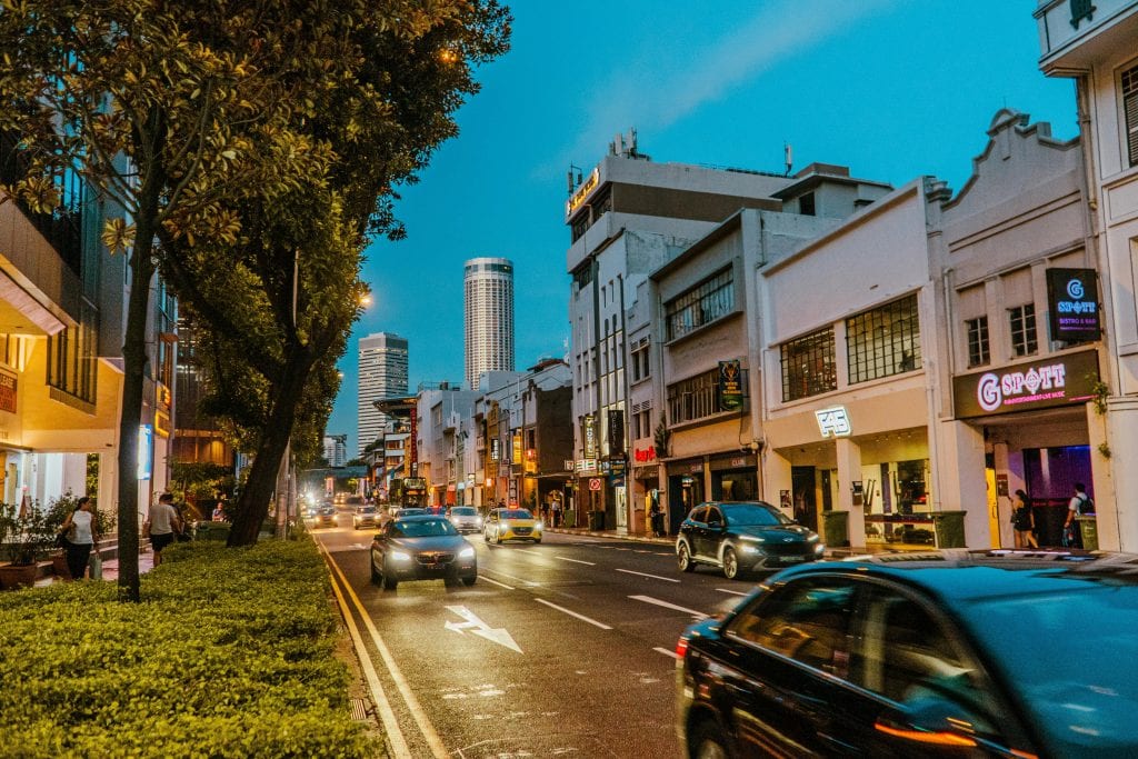 Vibrant urban scene showing busy street, historic architecture, and city life at dusk.
