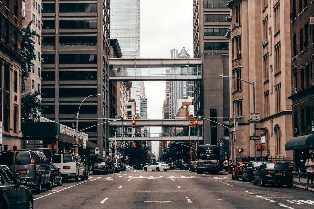 Dynamic view of a busy New York City street with traffic and towering skyscrapers.