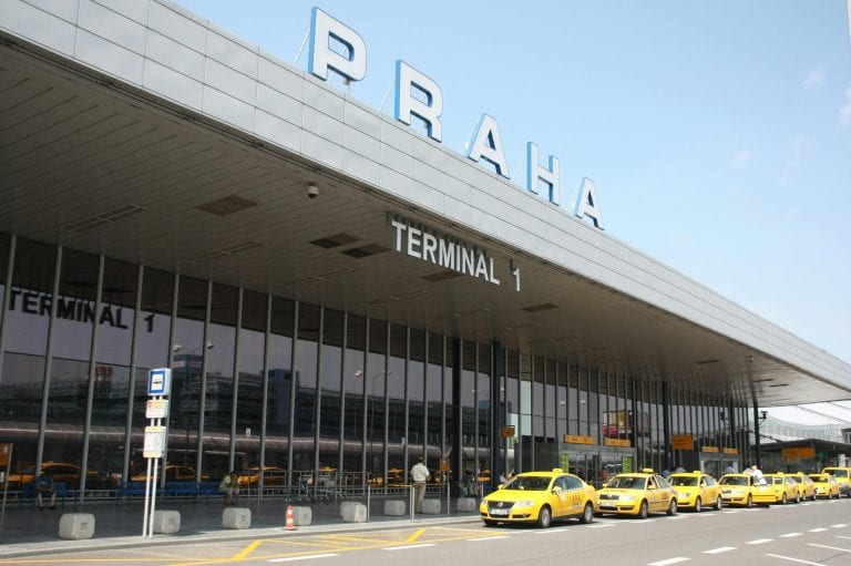 Exterior view of Praha Airport's Terminal 1 with a line of yellow taxis awaiting passengers.
