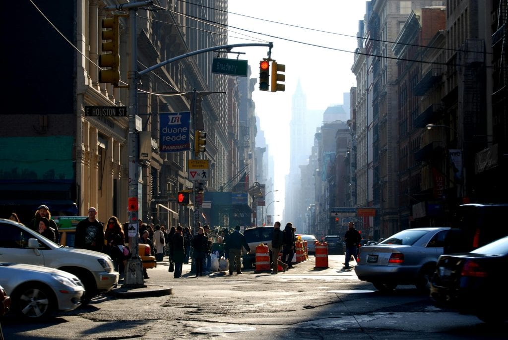 A bustling street scene in New York City with cars and people during daytime.