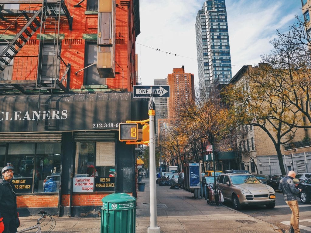 Urban street view featuring buildings, trees, and bustling activity in New York City.
