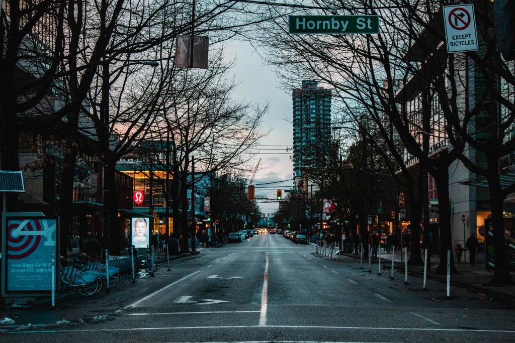 Nighttime urban street view of Hornby Street in downtown Vancouver, showcasing city life.