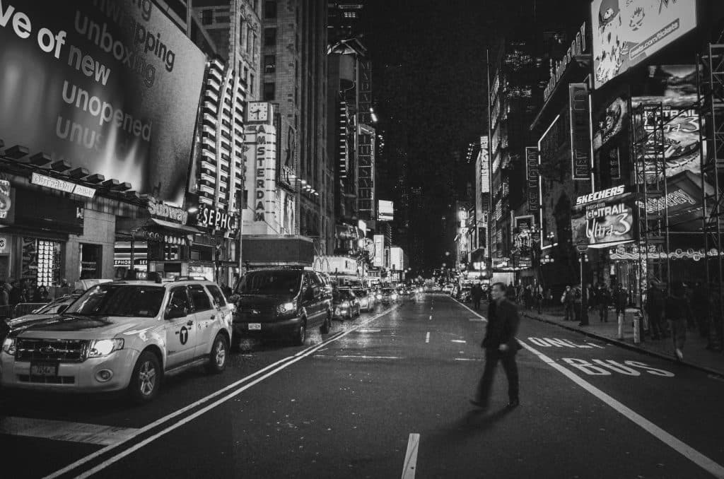 A bustling scene of New York City's Times Square at night, featuring city lights and urban life.