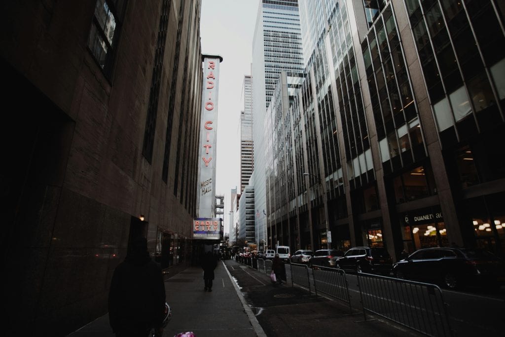 Iconic view of Radio City Music Hall surrounded by skyscrapers in NYC.