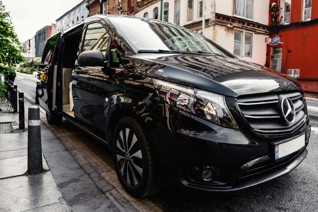 Eco Friendly Limo Service From LaGuardia: 5 Honest Facts in 2026 15 A stylish black Mercedes-Benz van parked on a bustling city street, showcasing luxury and modern design.