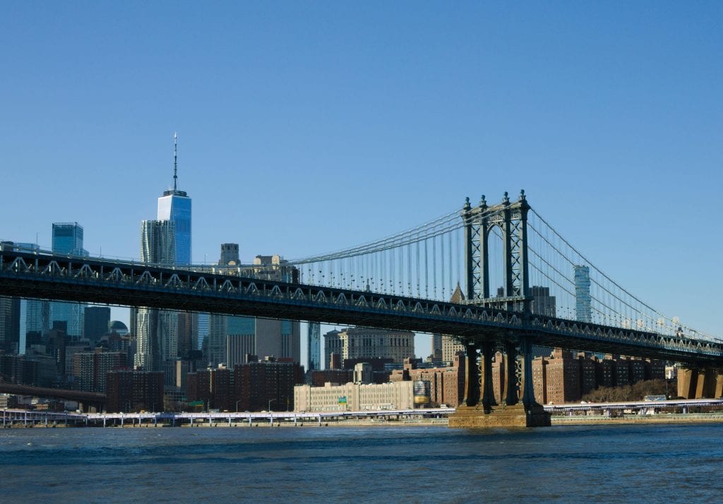 Scenic view of the Manhattan Bridge with the New York City skyline in the background on a clear day.