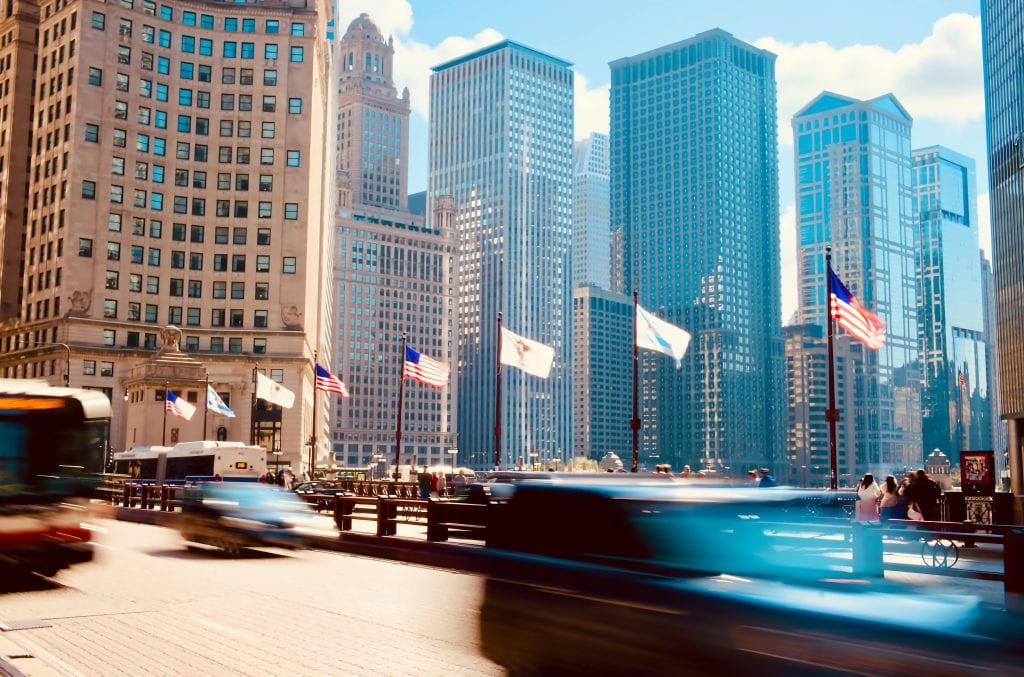 Vibrant cityscape of Chicago featuring bustling street activity and iconic skyscrapers on a sunny day.