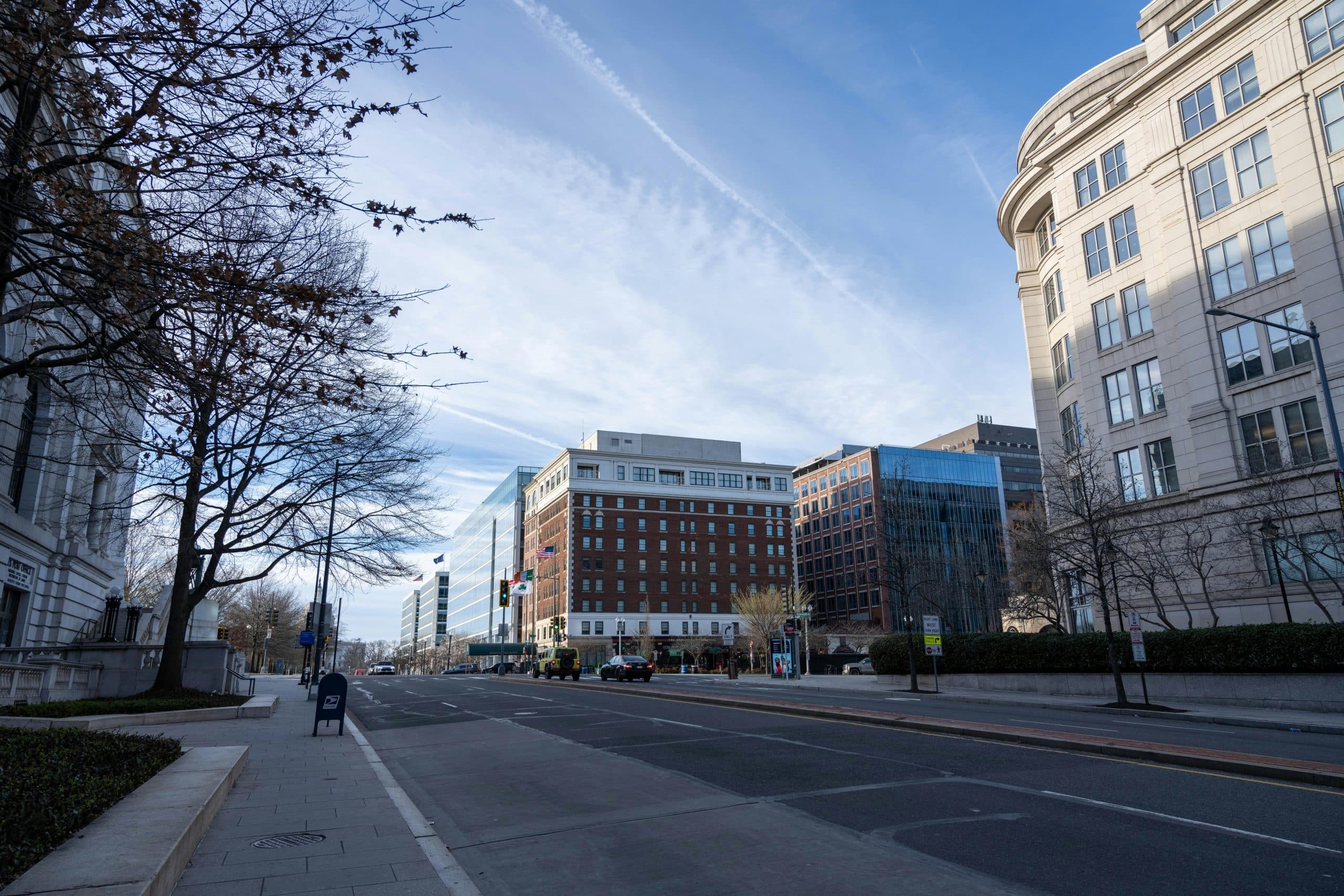 Scenic view of a street in Washington D.C. featuring modern and historic buildings under a clear sky.