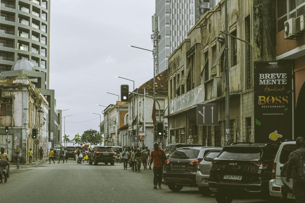 Bustling street scene in downtown Luanda, Angola with historic and modern buildings.