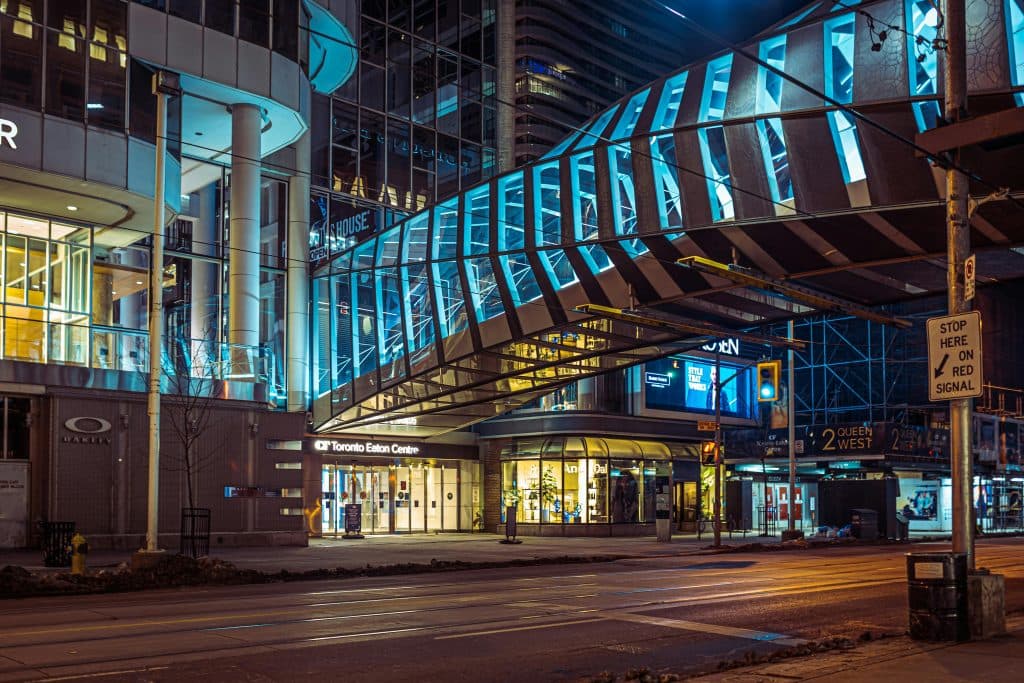 Nighttime view of the Toronto Eaton Centre and surrounding area, highlighting urban architecture and illuminated walkways.