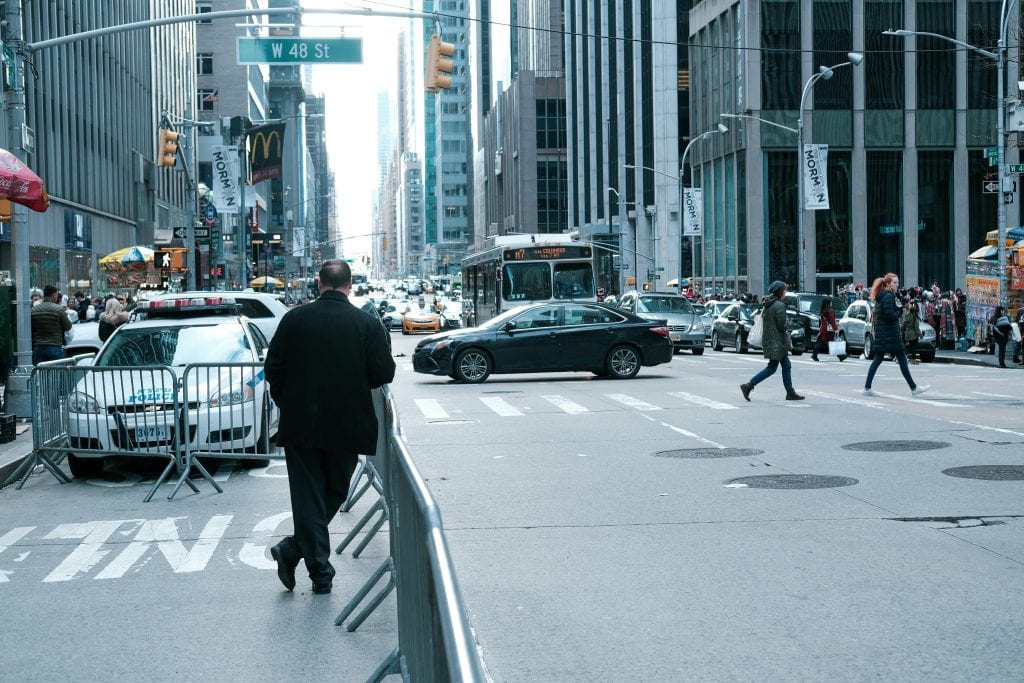 Reliable Limo to NYC in 2026: Your No-Stress Guide to Airport Transfers, Fixed Rates, Black Car Safety & Real-World Wins 1 Urban street view of traffic and pedestrians in New York City's bustling W 48 St area.