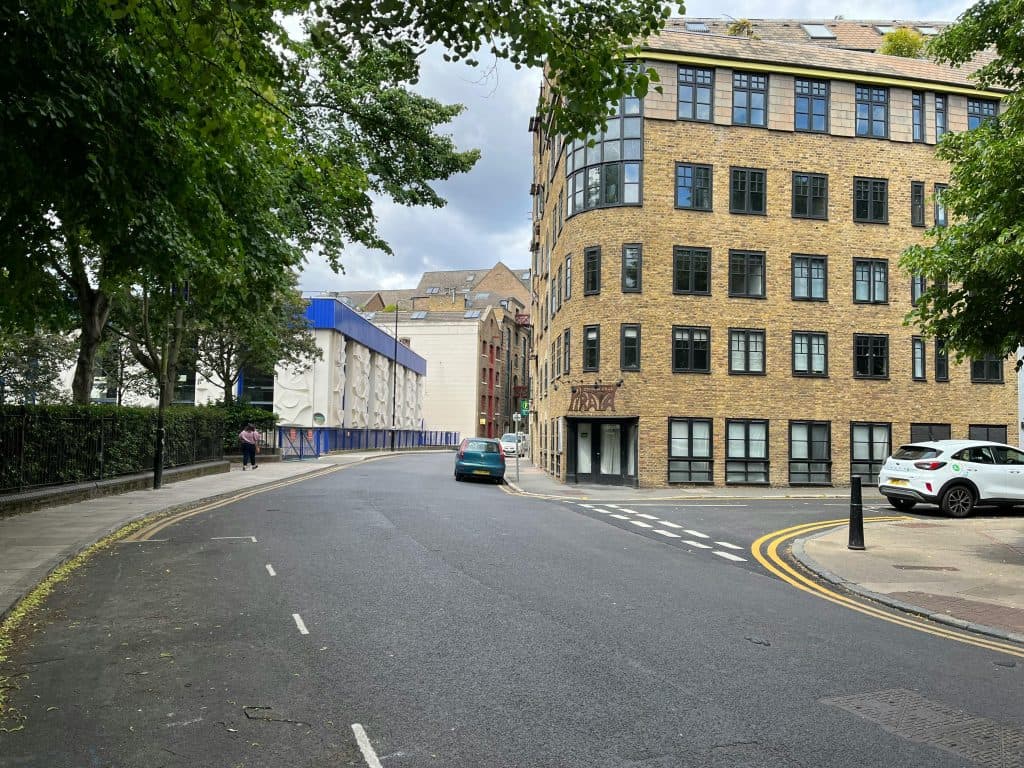 Charming street scene in Greater London with brick buildings and parked cars on a quiet day.
