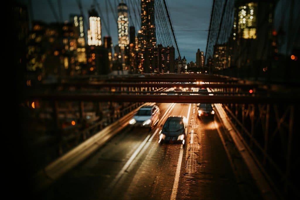 Eco Friendly Car Service from Newark to Brooklyn in 2026: Your Green Guide to Reliable Airport Transfers 9 Dynamic night view of Brooklyn Bridge with cars and city skyline in New York City.