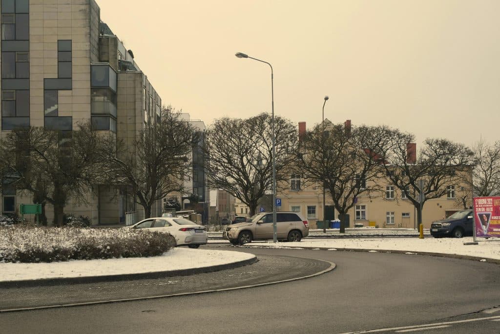 Reliable Car Service Near JFK in 2026: Your Ultimate Stress-Free Airport Transfer Guide 7 Snow-covered roundabout with buildings in Zielona Gรณra, Poland during winter.