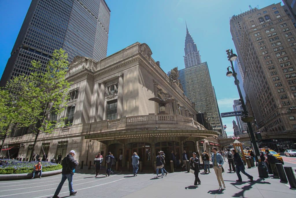 A vibrant street view of Grand Central Station with city skyscrapers in New York City.