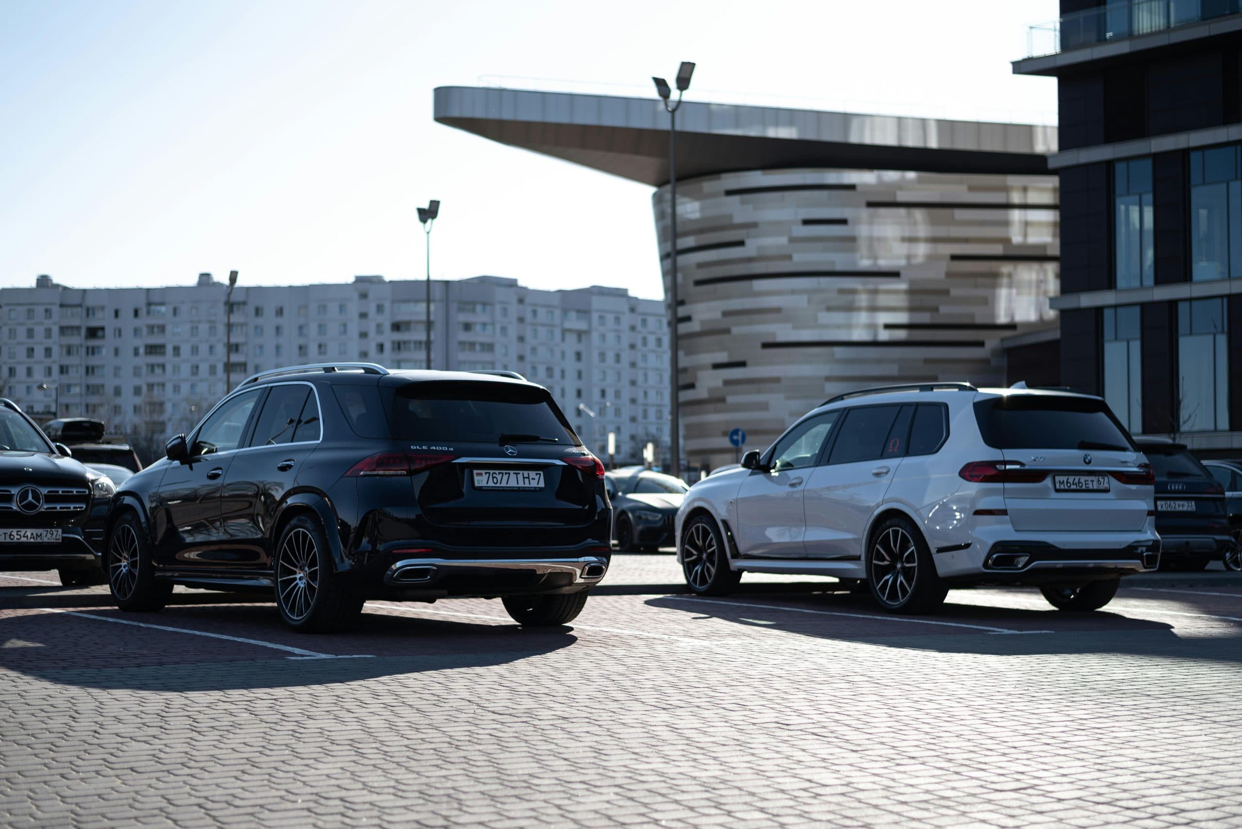 Blogs | Articles | News | Tips & Tricks | Video | FAQ | Infomation 9 Two luxury SUVs parked in an urban setting with modern buildings in the background.